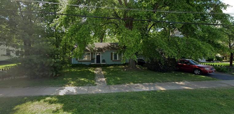 A house with a sidewalk and trees

Description automatically generated